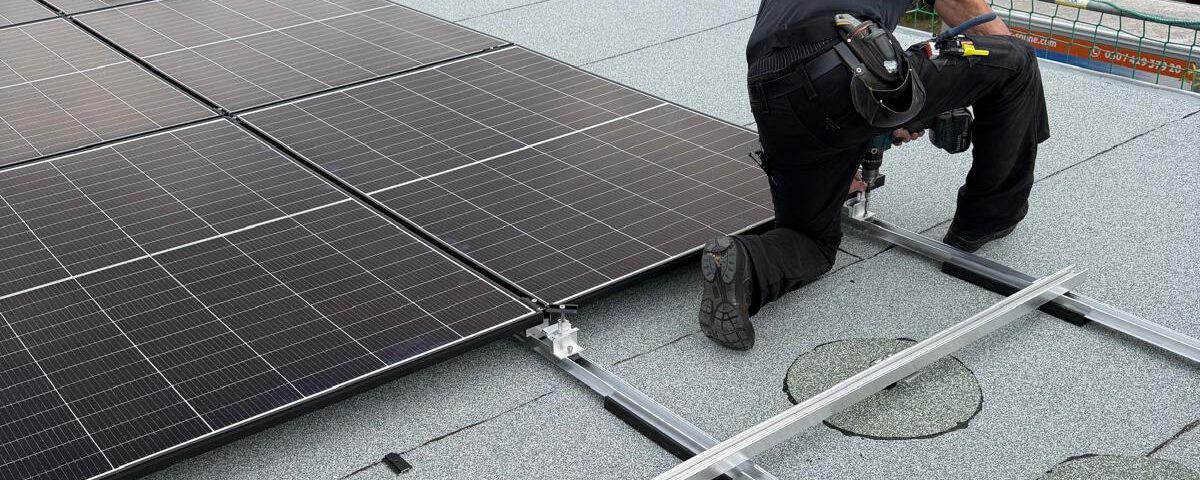 Installateur montiert die Unterkonstruktion einer Photovoltaikanlage auf einem Flachdach