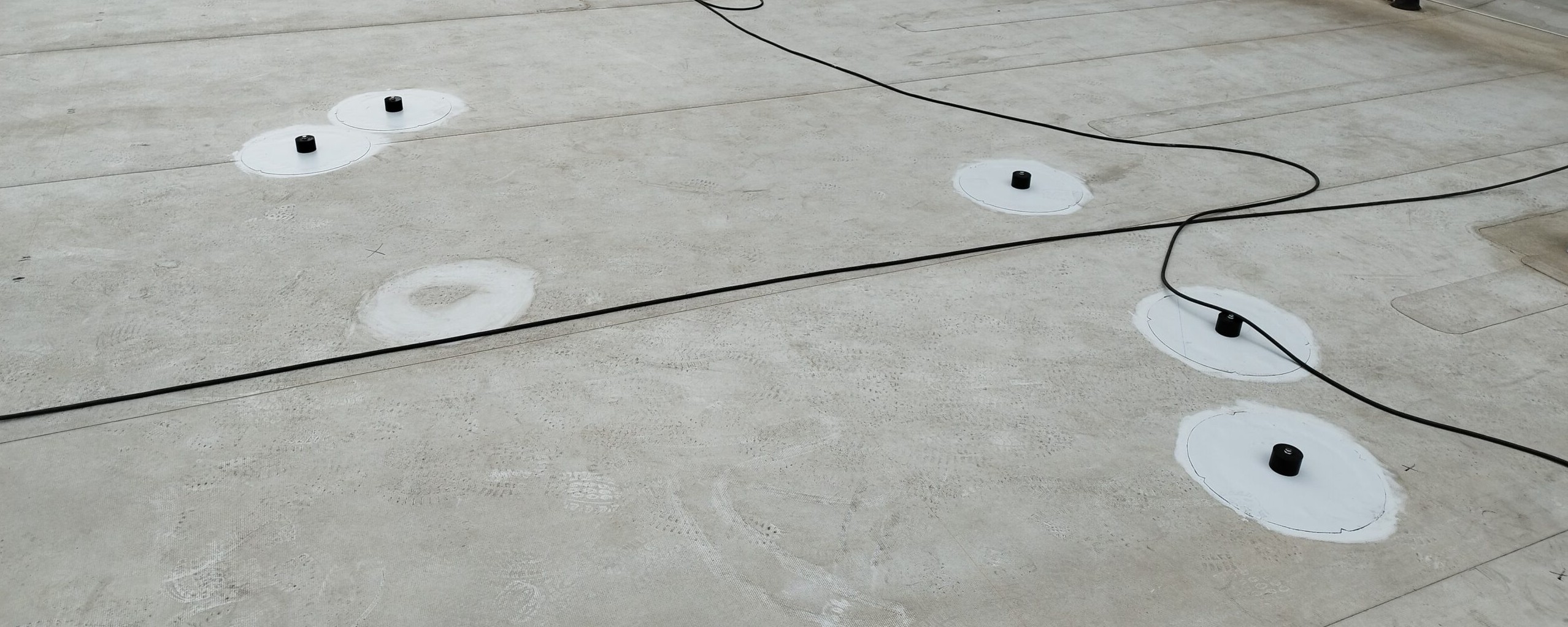 Mehrere Dachanker mit provisorisch verlegtem Kabel vor dem Aufbau der Photovoltaik-Unterkonstruktion