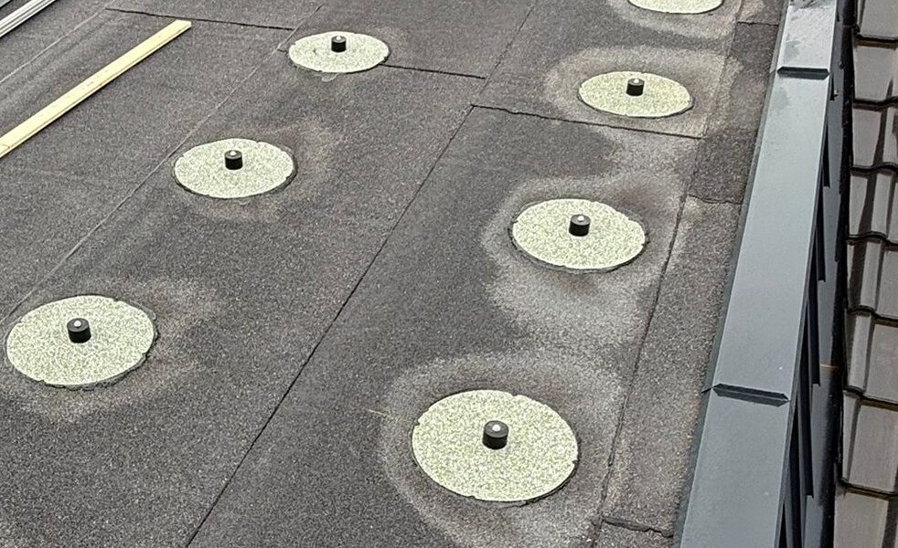 Vorbereitete Dachfläche mit mehreren kreisförmigen Montagepunkten für eine Photovoltaikanlage